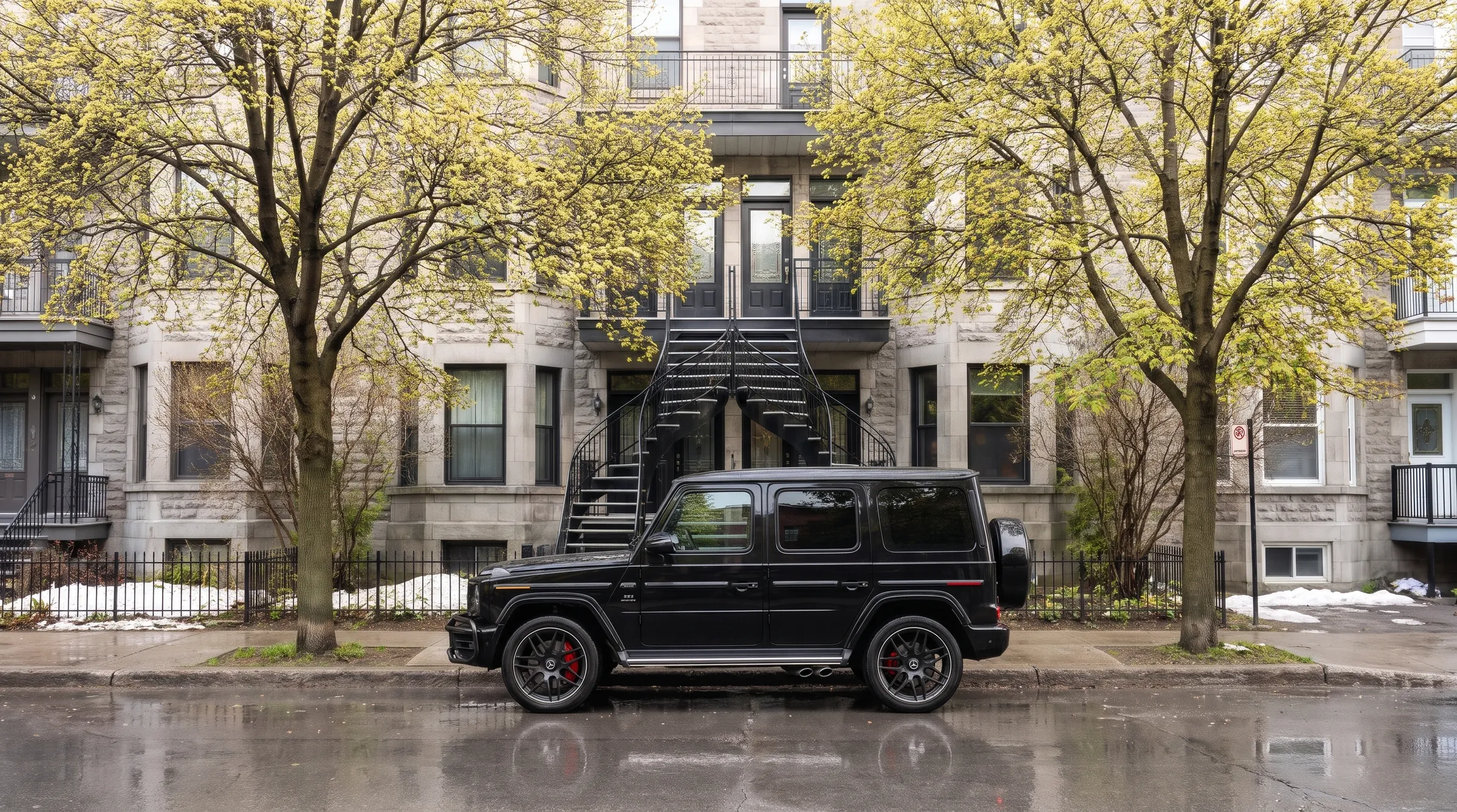 The same street in spring with a brand-new G 63 at the curb